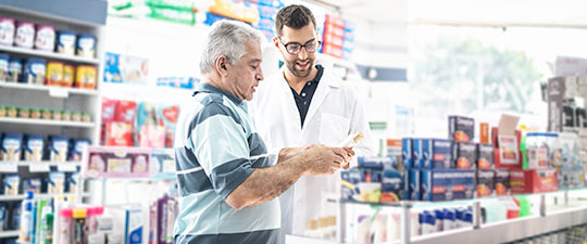 Male pharmacist helping male customer