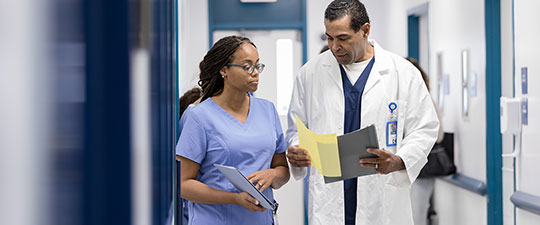 Two doctors discuss paperwork in urgent care