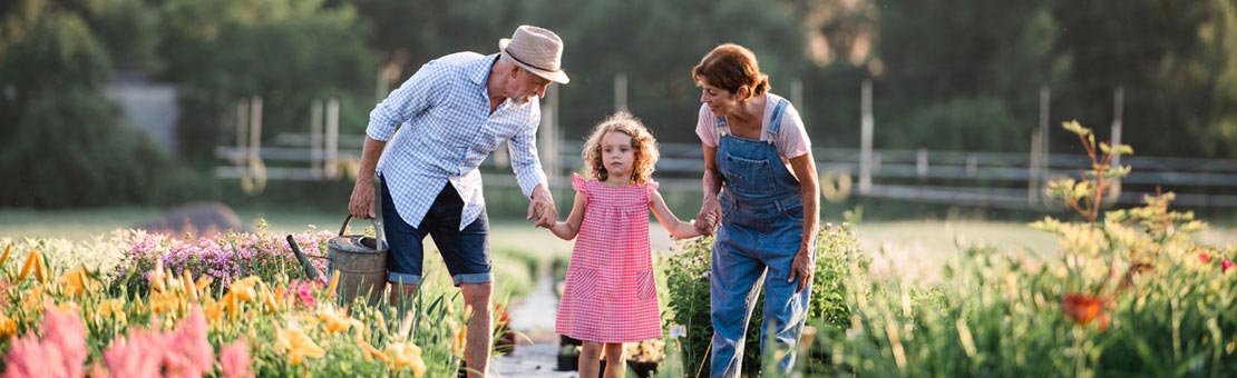 grandparents gardening with their granddaughter